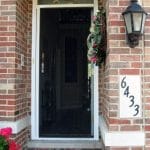 Plisse retractable door screen on a customer's front entrance door. Shown with Plisse retractable screen in use and front door open.